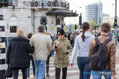 a woman using her smartphone while walking among the crowd